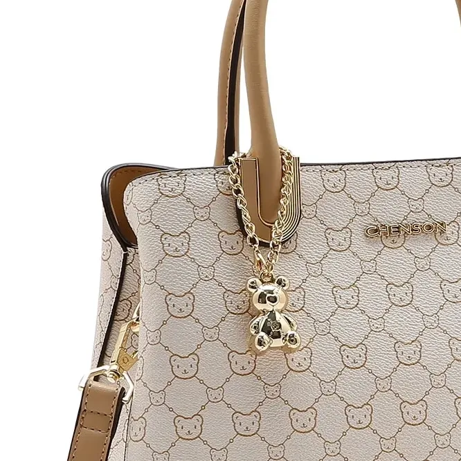 Close do pingente metálico em formato de ursinho da bolsa Chenson Tote Baby Urso bege